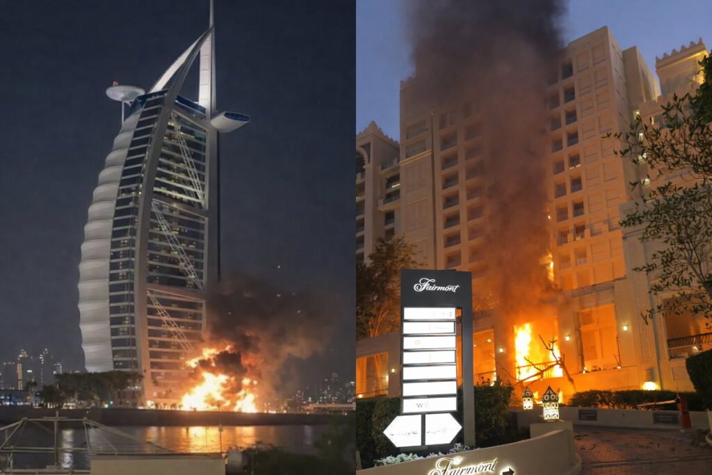 Night-time image showing Fairmont The Palm at Palm Jumeirah and the Burj Al Arab with visible impact damage, smoke and small fires from missile/drone debris.